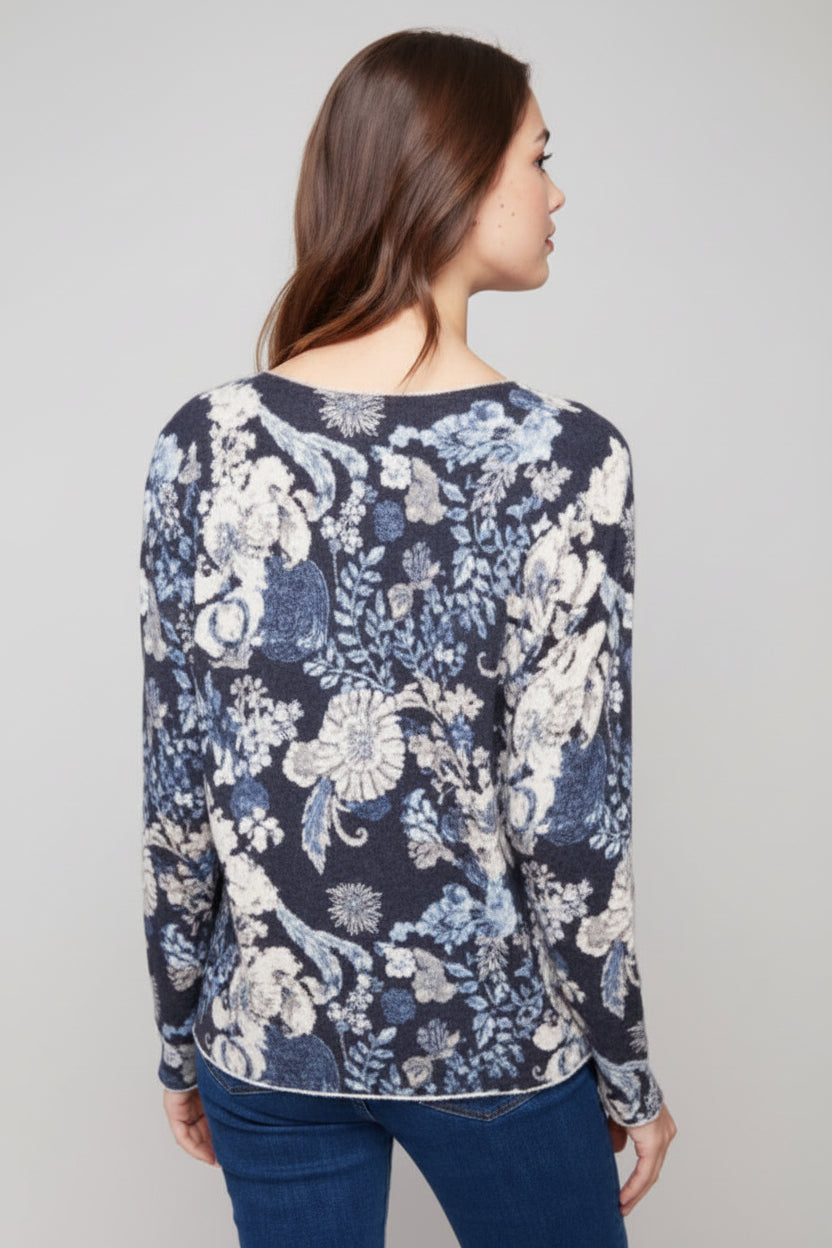 Woman wearing a floral-patterned sweater on a plain background