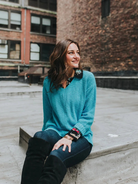 This 100% cotton slub seed stitch sweater from Avalin features long sleeves, a V-neck, center seam, ribbed cuffs and a ribbed straight hem with side slits. Sized to fall just below mid hip, it is machine washable and made in the USA. This lightweight garment is designed for all-day comfort and mobility. With a classic fit and timeless design, it provides the perfect wardrobe staples for any season.