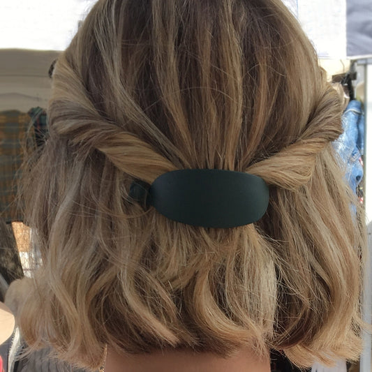 This hair clip is crafted from 100% acrylic and features a unique egg shape and matte finish. Measuring in at 2" x 1" x 1", this clip is secured with a twist closure.