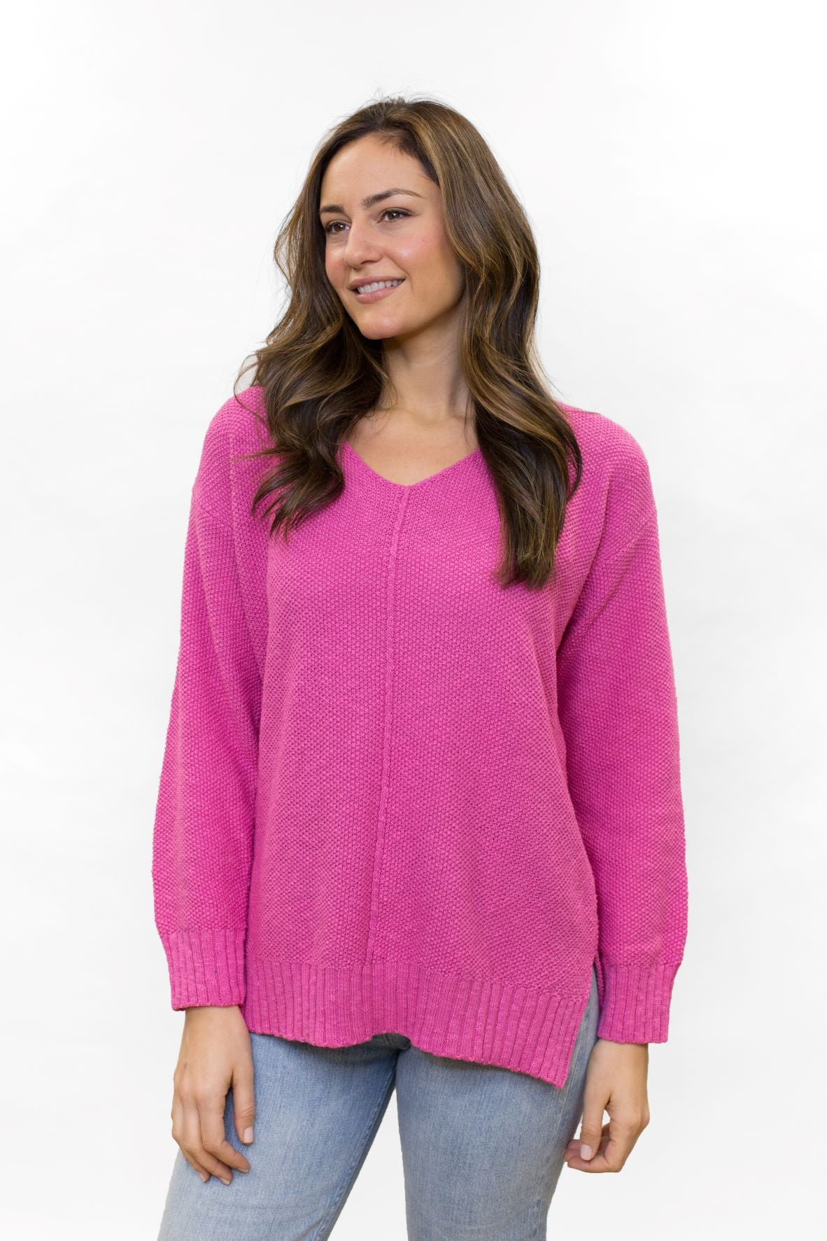 Fuchsia 100% cotton slub seed stitch sweater by Avalin. Features long sleeves, v-neck, center seam, ribbed cuffs and ribbed straight hem with side slits. Falls just below mid hip.