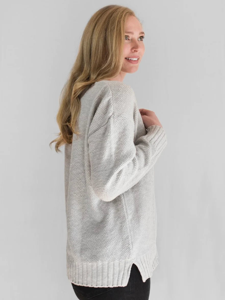This 100% cotton slub seed stitch sweater from Avalin features long sleeves, a V-neck, center seam, ribbed cuffs and a ribbed straight hem with side slits. Sized to fall just below mid hip, it is machine washable and made in the USA. This lightweight garment is designed for all-day comfort and mobility. With a classic fit and timeless design, it provides the perfect wardrobe staples for any season.