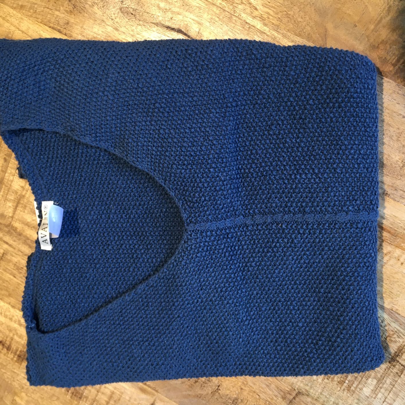 100% cotton slub seed stitch sweater by Avalin. In color Indigo navy blue  with long sleeves, v-neck, center seam, ribbed cuffs and ribbed straight hem with side slits. Falls just below mid hip.  Made in USA.