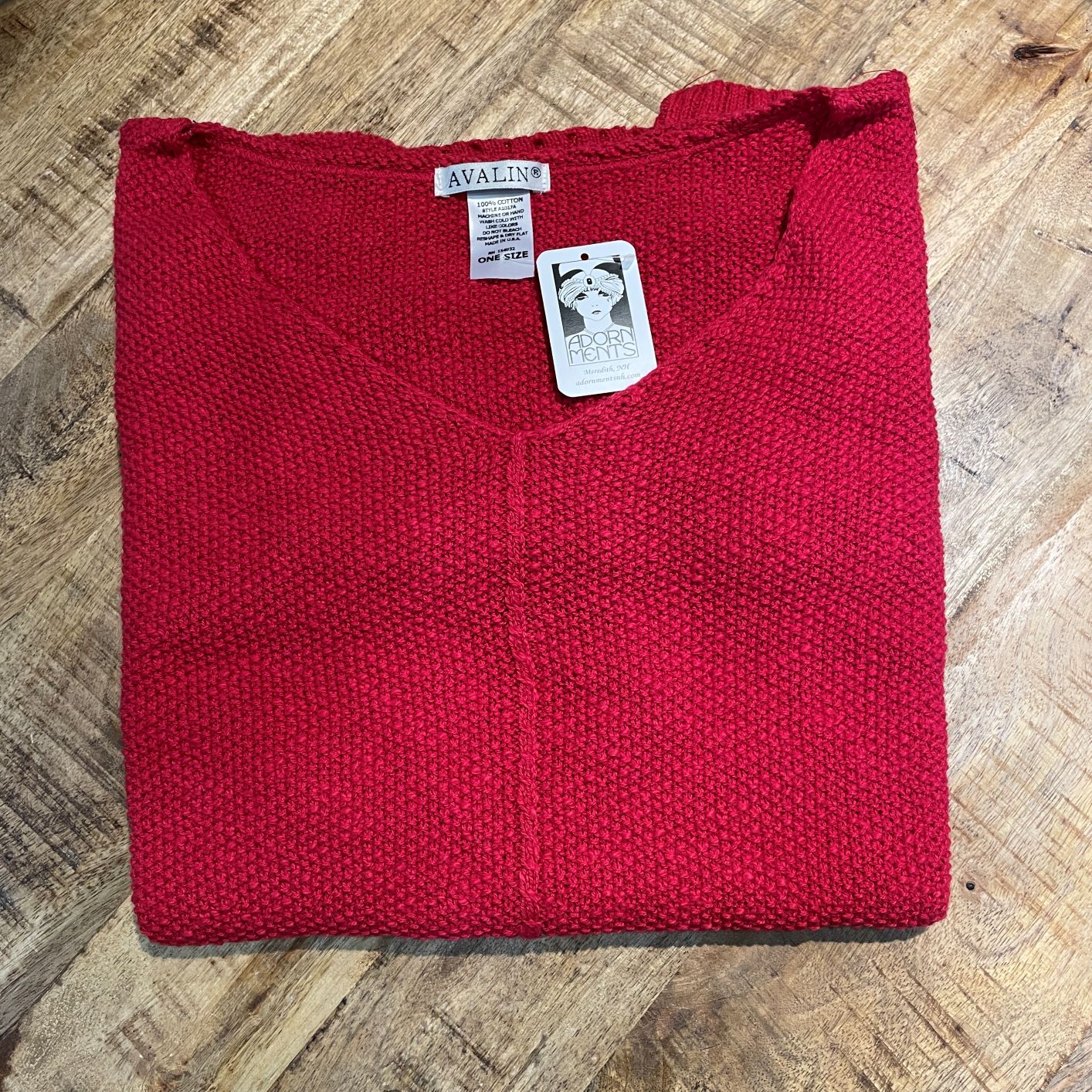 Red 100% cotton slub seed stitch sweater by Avalin. Features long sleeves, v-neck, center seam, ribbed cuffs and ribbed straight hem with side slits. Falls just below mid hip.