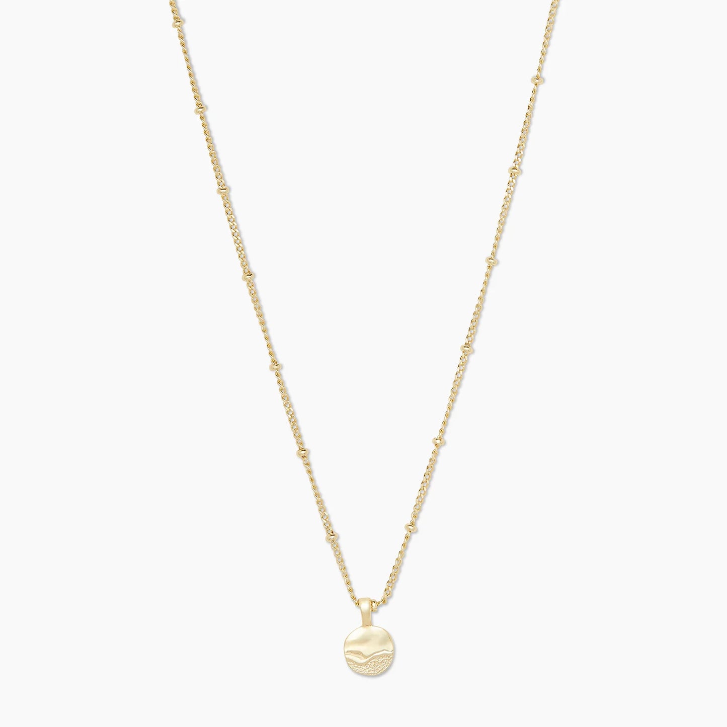 Beach days never have to end with the Shorebreak Necklace. Crafted with 18k gold plated brass, this delicate chain features evenly spaced tiny balls and an etched pendant reminiscent of a sandy shoreline.