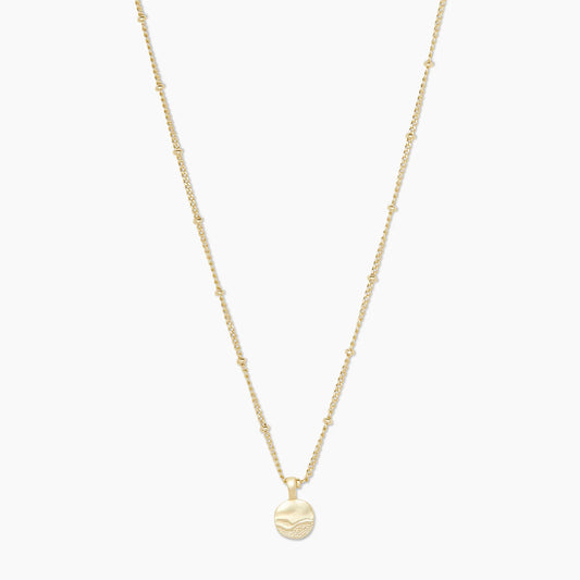 Beach days never have to end with the Shorebreak Necklace. Crafted with 18k gold plated brass, this delicate chain features evenly spaced tiny balls and an etched pendant reminiscent of a sandy shoreline.